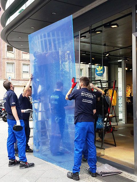 ISM Mitarbeiter tragen eine Glasscheibe